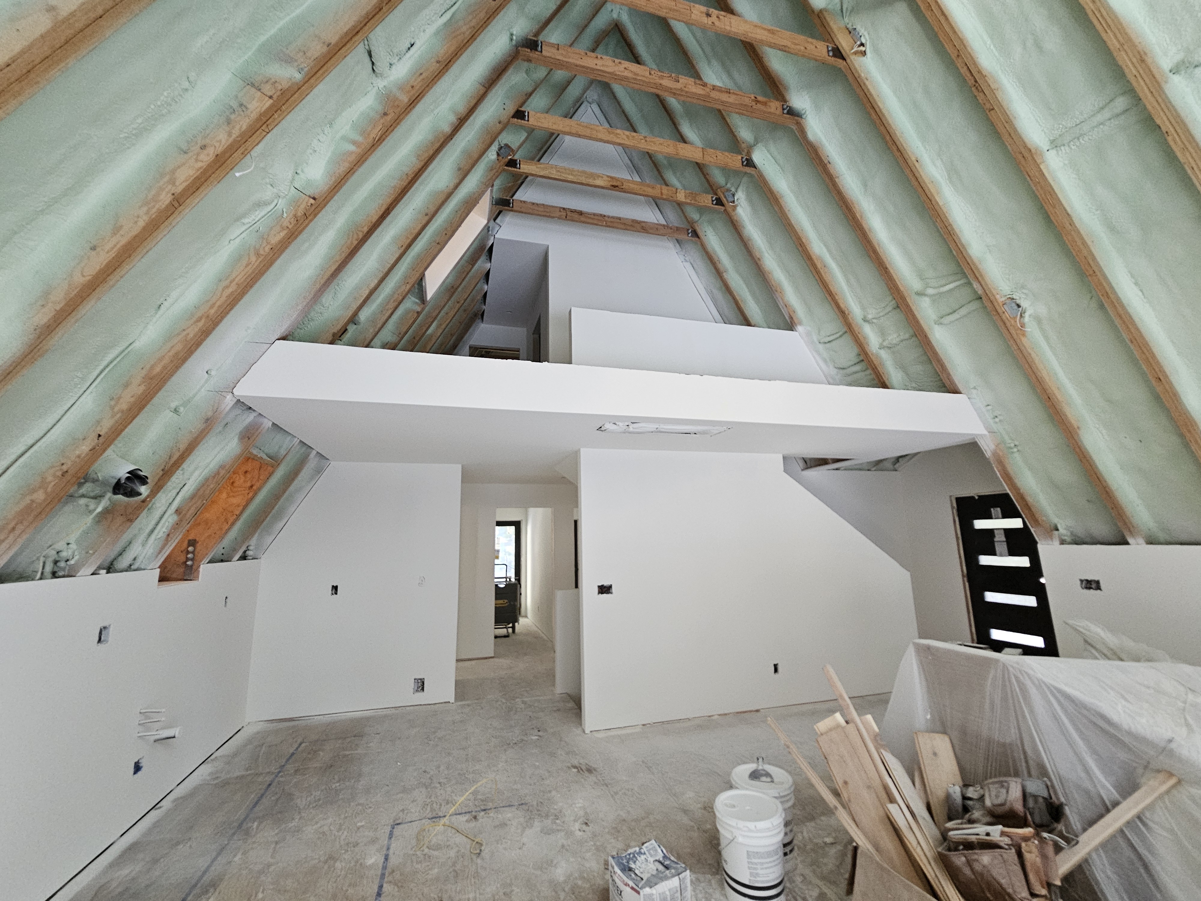 Attic space with spray foam insulation and drywall — comprehensive interior finishing
